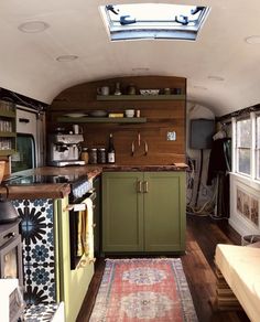 a kitchen with green cabinets and an area rug