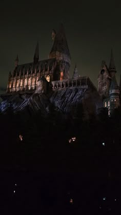 hogwart's castle lit up at night in the dark