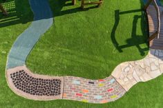 an aerial view of a garden with grass and stepping stones on the ground, including a wooden bench