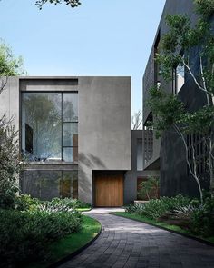 a modern house in the middle of some trees and grass with a walkway leading to it