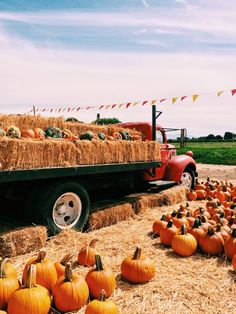 pumpkins and hay bales in the back of a truck