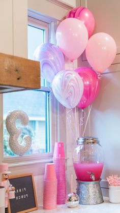 pink and white balloons are in a vase next to a sign that says 3 on it