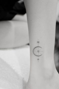 a small moon and star tattoo on the ankle