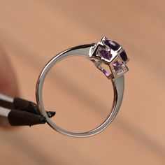 It is natural amethyst ring, the main stone is about 7mm*7mm, round cut, weight about 1.25 carats. The basic metal is sterling silver and plated with rhodium. To change the metal to a solid gold (white/rose) or platinum is also available, please ask for a quotation if you want. You can also go to my shop Home for more elegant rings: https://www.etsy.com/shop/godjewelry?ref=hdr_shop_menu Natural amethyst is February birthstone. More natural amethyst rings: https://www.etsy.com/shop/godjewelry?ref Purple Cubic Zirconia Birthstone Ring, Purple Crystal Ring With Center Stone In Round Cut, Amethyst Ring With Brilliant Cut Cubic Zirconia, Round Amethyst Ring With Prong Setting For Anniversary, Purple Crystal Ring With Round Cut Center Stone, Purple Cubic Zirconia Birthstone Ring Round Cut, Purple Birthstone Ring With Prong Setting, White Gold Amethyst Birthstone Ring With Prong Setting, Brilliant Cut Amethyst Ring In White Gold