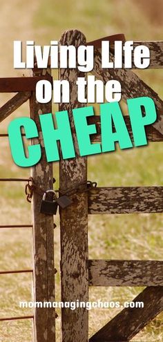 a wooden gate with the words living life on the cheap next to it in front of an open field