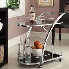 a bar cart with drinks and fruit on it in a room next to a chair