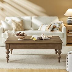 a living room with a white couch and wooden coffee table in front of the sofa