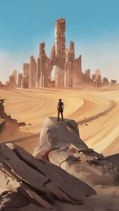 a man standing on top of a desert next to a tall building in the distance