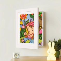 a painting hanging on the wall next to a clock and a small toy rabbit sitting in front of it