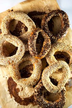 several bagels sitting on top of a piece of parchment paper covered in brown sugar and sprinkles