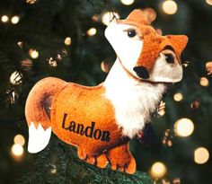 an ornament shaped like a fox hanging from a christmas tree