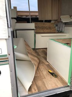 the interior of an rv with wood flooring and white cabinets in place for storage