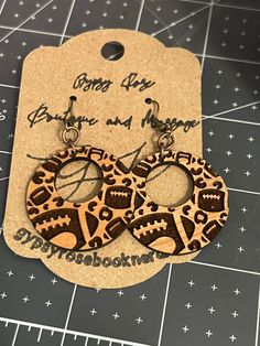 the earrings are made out of wood and have an animal print pattern on them,