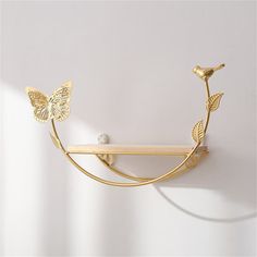 a wall mounted shelf with two butterflies on it and a ball hanging from the top