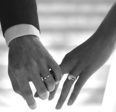 two people holding hands with rings on their fingers