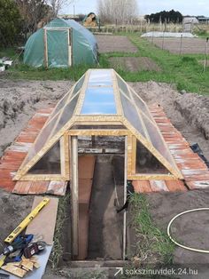 an unfinished building with a skylight in the center and some tools on the ground