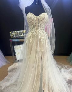 a wedding dress on display in front of a mannequin's headdress