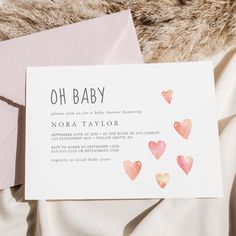 a baby shower is shown with pink hearts on the inside of it and an envelope that says oh baby