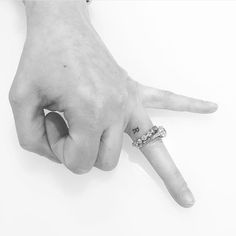 black and white photograph of a person's hand with a ring on the middle finger