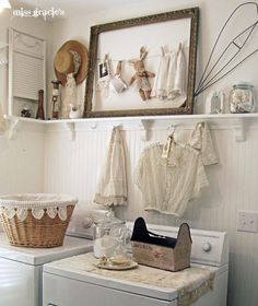 a white washer and dryer sitting next to each other in a room with pictures on the wall