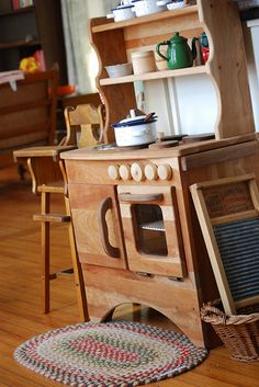 an old fashioned wooden stove and oven in a room with hardwood flooring, furniture and rugs