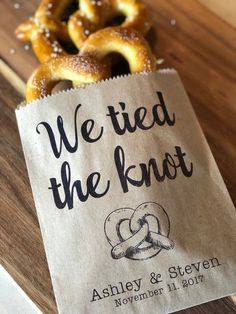 some pretzels sitting on top of a wooden table next to a sign that says we tied the knot