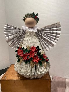 an origami angel with red flowers on it