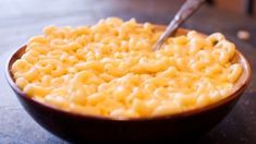 a wooden bowl filled with macaroni and cheese