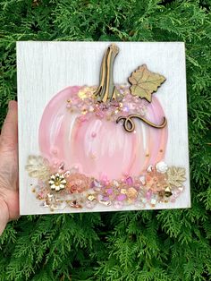 a hand holding up a card with a pink pumpkin and gold leaf decoration on it