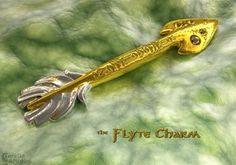 a gold and silver brooch with the word, the flyte charm on it