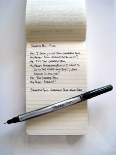 a notepad with writing on it and a pen resting on top of the paper