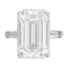 an emerald - cut diamond ring with baguetts on the shoulders and side stones