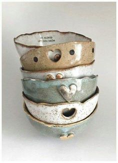 four ceramic bowls stacked on top of each other with hearts in the middle and words above them