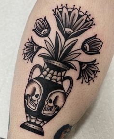 a black and white photo of a vase with flowers in it on someone's leg