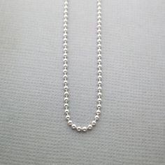 This is our Sterling Silver Ball Chain with a Spring Ring Closure. You can easily slide our charms on and off this chain. It has a shiny finish. 14" is the size recommended for children under 10 or as a choker chain.18" is the most popular size for women.20" is a popular length for men.If you are unsure of the right length for you, drape a piece of string around your neck to your preferred length, then measure the string on a ruler. Choose the available length that is closest to your measurement Silver Chain Necklace With Lobster Clasp And Round Beads, Silver Ball Chain Necklace For Everyday, Silver Necklace With Box Chain And Round Beads, Silver Jewelry With Box Chain And Round Beads, Silver Satellite Chain Necklace With Round Pendant, Everyday Silver Ball Chain Necklace, Silver Round Beads Chain Necklace Gift, Silver Chain Necklace With Round Beads For Gift, Silver Dog Tag Ball Chain Necklace