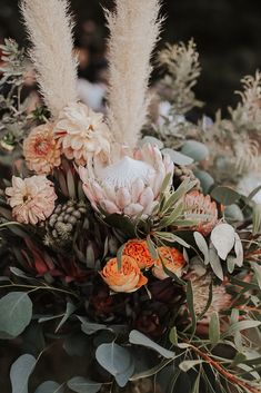 an arrangement of flowers and greenery in a vase