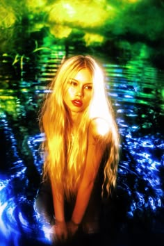 a woman with long blonde hair sitting in the water