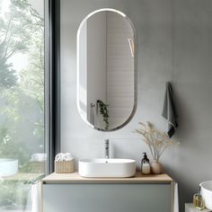 a bathroom with a sink, mirror and plants on the counter in front of it