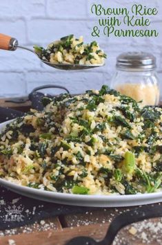 brown rice with spinach and parmesan in a white bowl on a wooden table