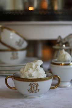 a white table topped with two cups filled with whipped cream