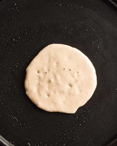 an uncooked flat bread in a frying pan