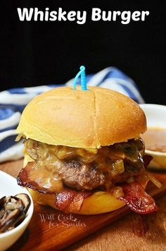 there is a hamburger with bacon on it and a small blue candle in the middle