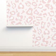 a wall with a pink and white animal print pattern next to a light wood floor