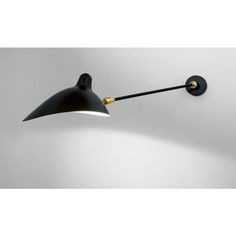 a black and gold wall light on a white wall with the arm extended to it's left side