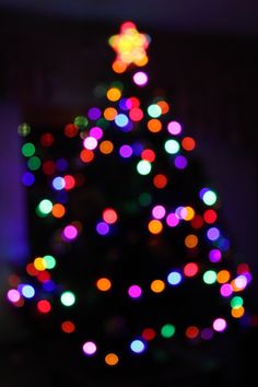 a lit up christmas tree with multicolored lights on it's top and bottom