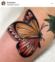 a colorful butterfly tattoo on the leg