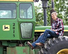 a man sitting on the front of a tractor