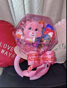 a pink teddy bear sitting on top of a pillow