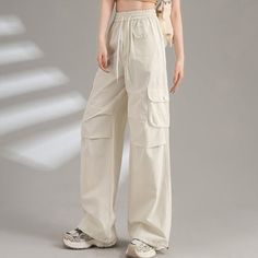 Style: Casual/Street/Vintage/Y2K/Punk/Hip PopFabric Content: CottonFit Type: Regular fitDesign: These casual pants shaped to a straight-leg fit, sits to a flattering waist with drawstring detail, with cargo pockets patched and long straps design. Beige Cotton Y2k Style Bottoms, Casual Beige Mid-rise Wide Leg Pants, Casual Mid-rise Wide Leg Pants For Streetwear, Y2k Wide Leg Solid Color Bottoms, Casual Beige Mid-rise Pants, Casual Mid-rise Beige Pants, Wide Leg Cargo Pants, Drawstring Detail, Y2k Punk