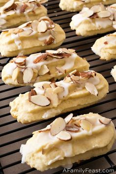 cookies with almonds and icing sitting on a cooling rack